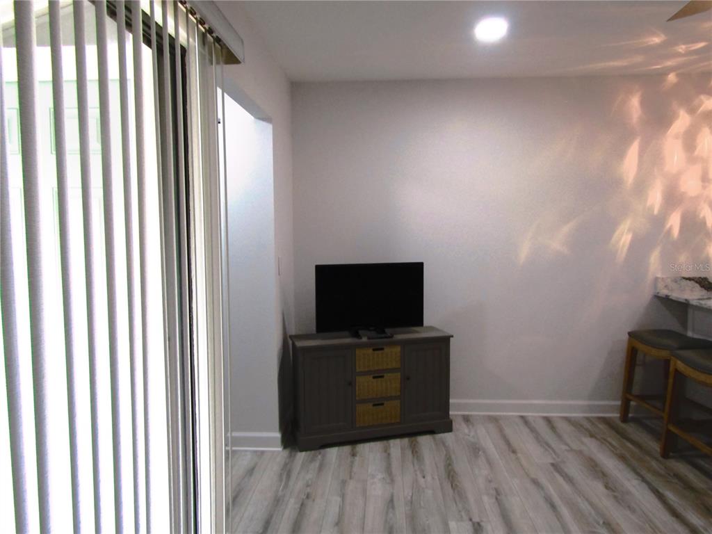 3531 Longmeadow, Unit 16 Sarasota, FL 34235 - Photo 25 of 29 a room with wooden floor and a flat screen tv