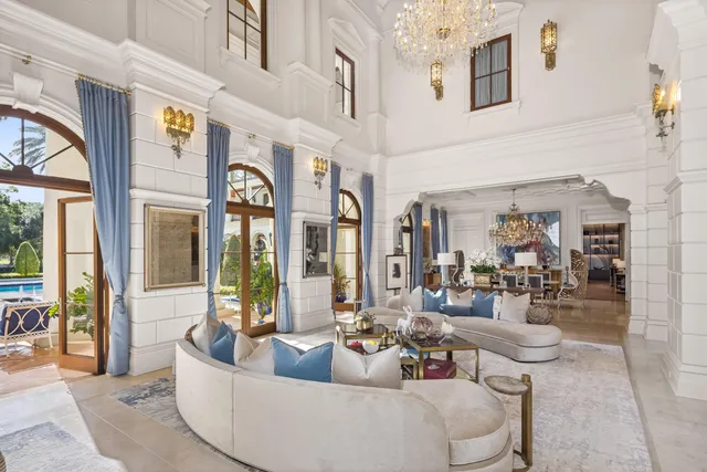 a living room with furniture a bookshelf and a large window