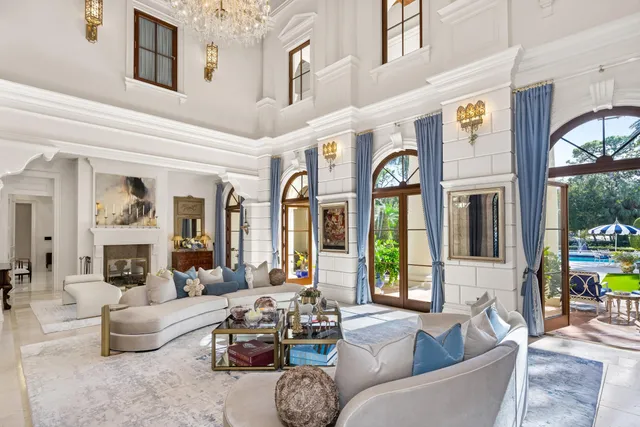 a living room with furniture a bookshelf and a large window