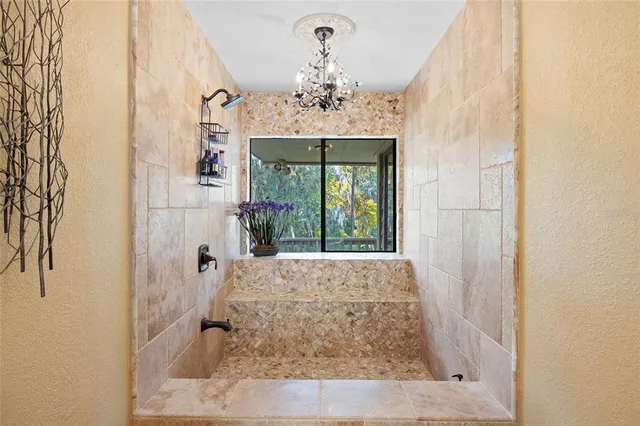 a spacious bedroom with a large bed and a chandelier