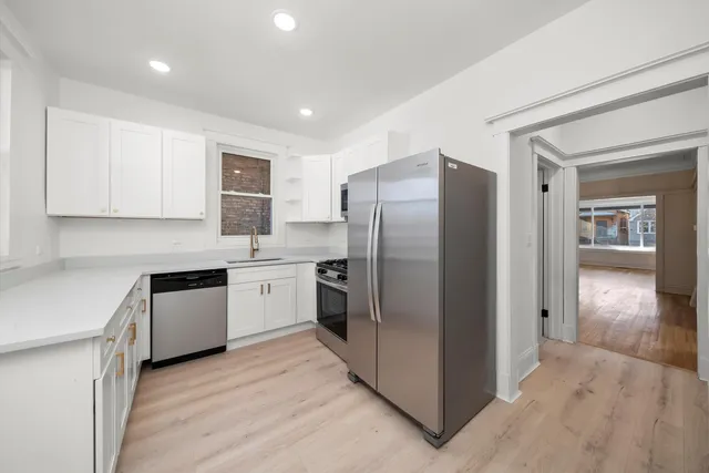 a kitchen with stainless steel appliances granite countertop a refrigerator and a stove top oven