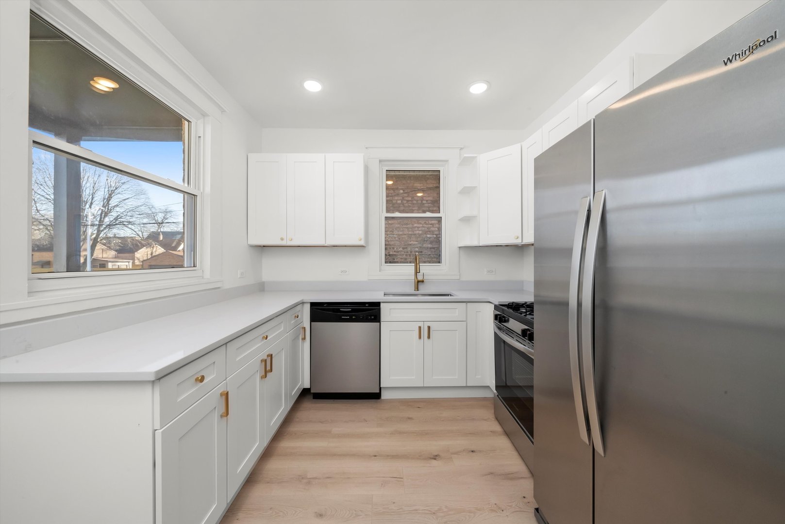 7955 South Colfax Avenue Chicago, IL 60617 - Photo 13 of 43 a kitchen with stainless steel appliances granite countertop a refrigerator and a stove top oven