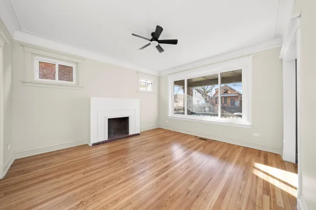 a view of empty room with wooden floor and fireplace