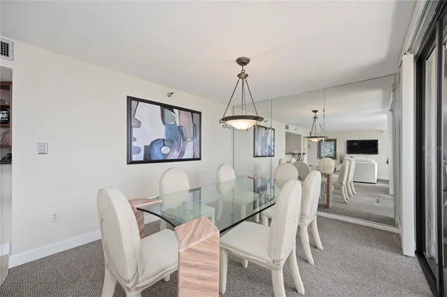 a dining room with furniture a chandelier and wooden floor