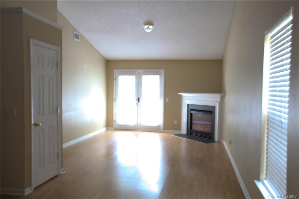 5004 Deerton Road Charlotte, NC 28269 - Photo 2 of 7 a view of empty room with wooden floor and fireplace