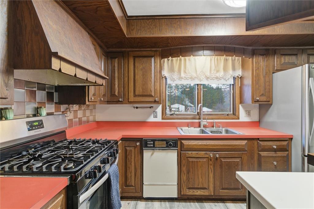 312 Flatwoods Road Vanderbilt, PA 15486 - Photo 14 of 50 a kitchen with stainless steel appliances granite countertop a stove a sink and a refrigerator