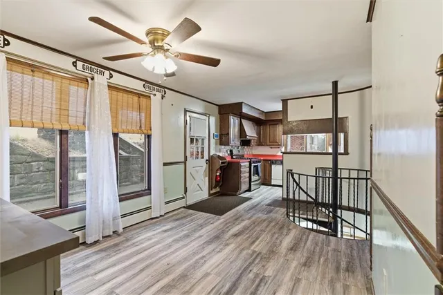 a view of a kitchen with refrigerator and wooden floor