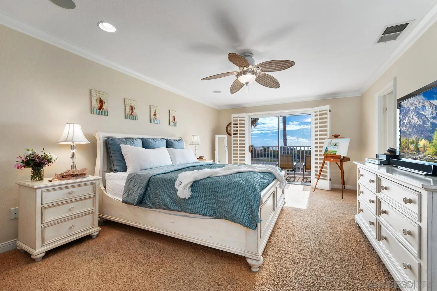 6891 Tradewinds Drive Carlsbad, CA 92011 - Photo 30 of 55 a spacious bedroom with a large bed and a chandelier