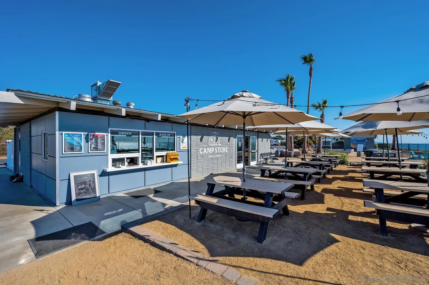 6891 Tradewinds Drive Carlsbad, CA 92011 - Photo 51 of 55 a patio with a table and chairs under an umbrella