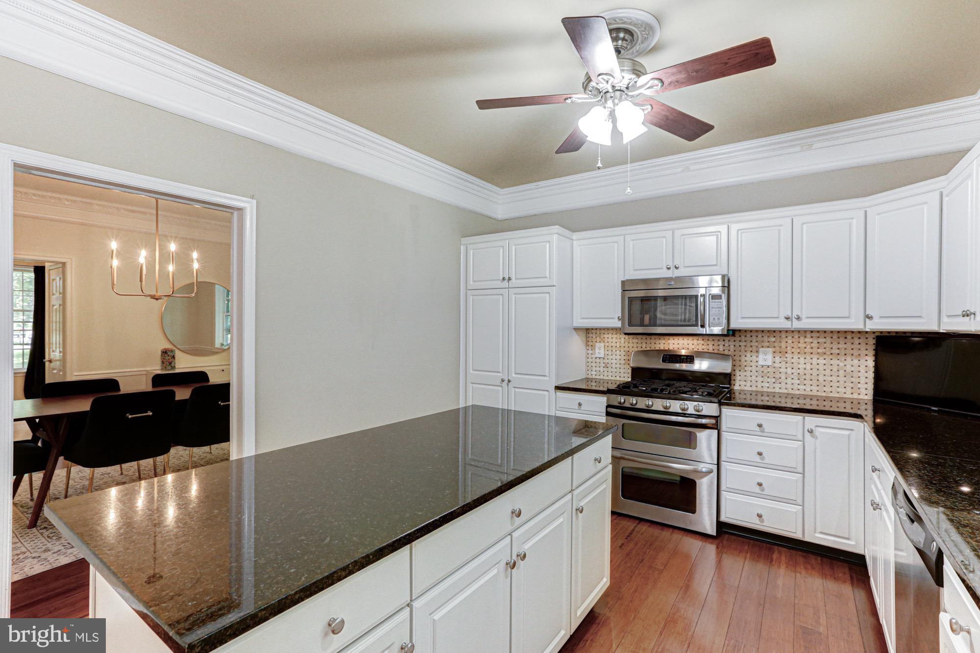 104 Dungarvan Drive Middletown, DE 19709 - Photo 18 of 45 a kitchen with stainless steel appliances a stove a sink a microwave and cabinets