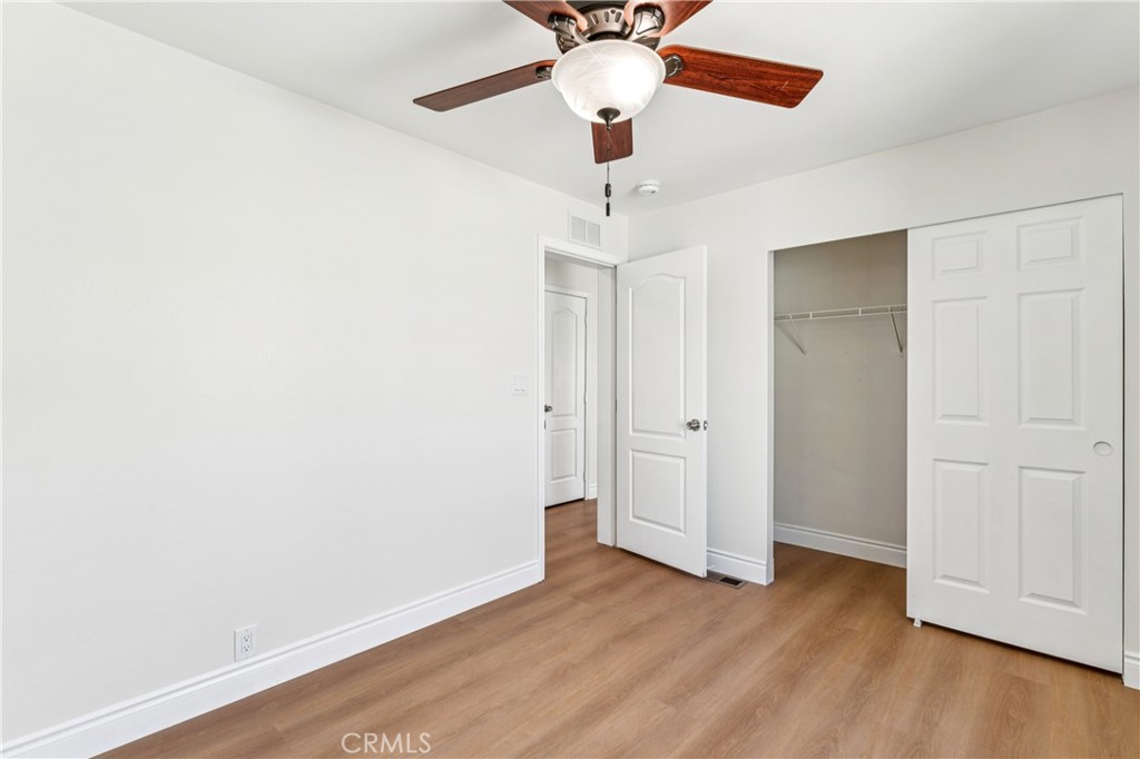 10550 Dunlap Crossing Road, Unit 141 Whittier, CA 90606 - Photo 15 of 38 an empty room with wooden floor chandelier fan and closet area
