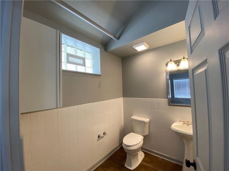 1108 4th Avenue Coraopolis, PA 15108 - Photo 7 of 15 a bathroom with a toilet a sink and a mirror