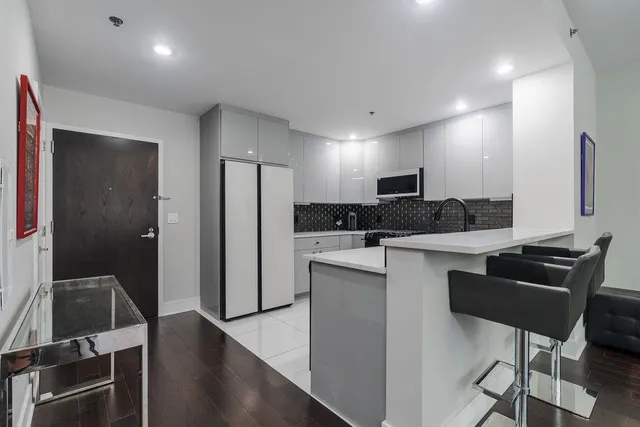 a kitchen with stainless steel appliances kitchen island granite countertop a refrigerator and a stove top oven