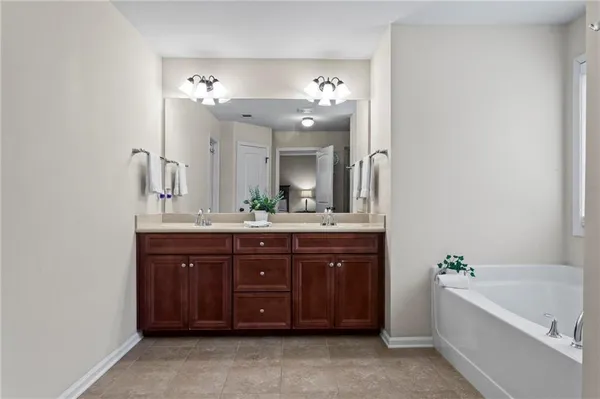 a spacious bathroom with a tub sink and mirror
