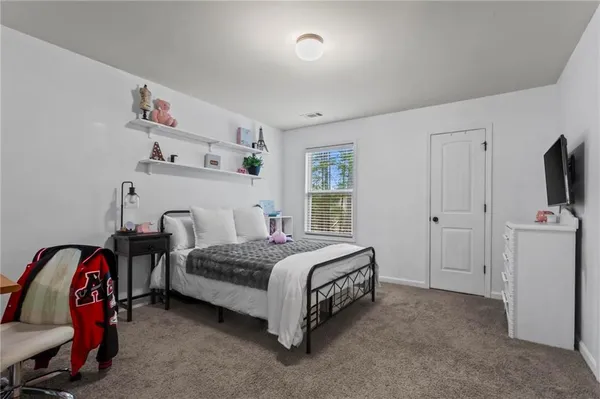 a spacious bedroom with a bed and a window