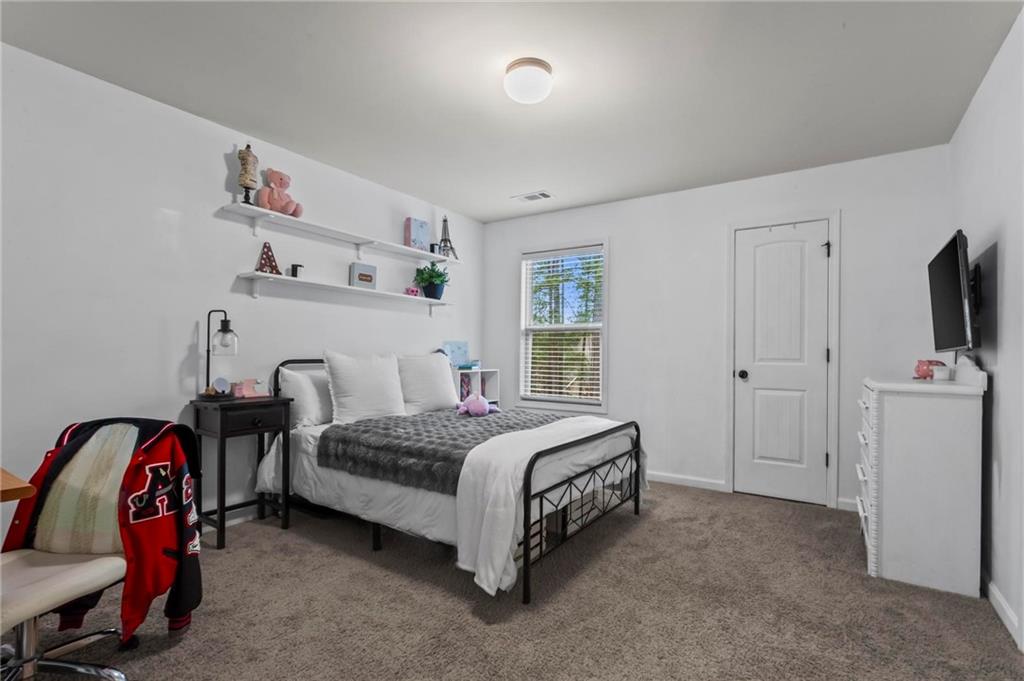 156 Starry Night Way Dallas, GA 30132 - Photo 14 of 28 a spacious bedroom with a bed and a window