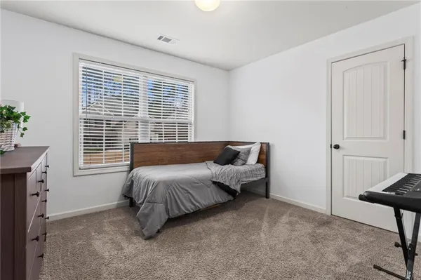 a spacious bedroom with a bed and a window