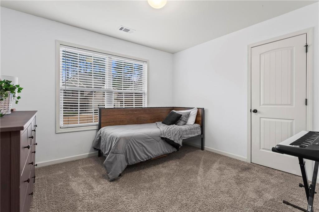 156 Starry Night Way Dallas, GA 30132 - Photo 16 of 28 a spacious bedroom with a bed and a window