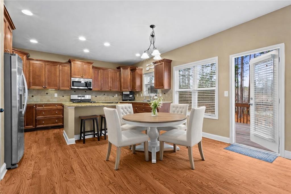 156 Starry Night Way Dallas, GA 30132 - Photo 3 of 28 a kitchen with kitchen island granite countertop wooden floors and stainless steel appliances