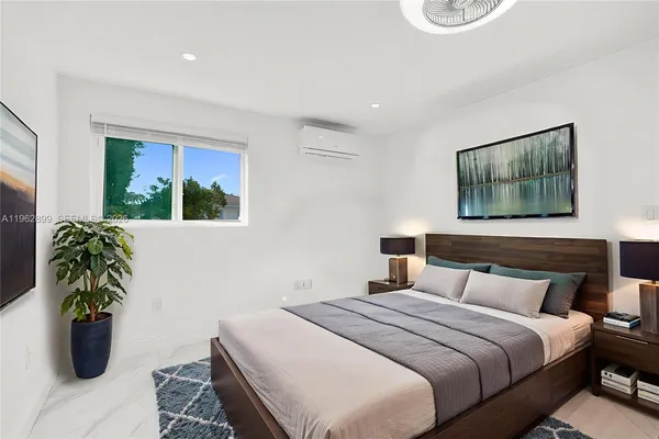 a bedroom with a bed and a potted plant