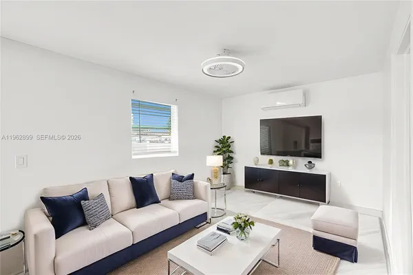 a living room with furniture a flat screen tv and a window