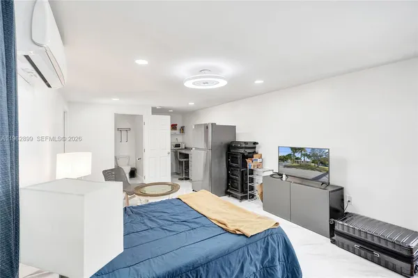 a kitchen with stainless steel appliances kitchen island granite countertop a refrigerator and a stove top oven with wooden floor