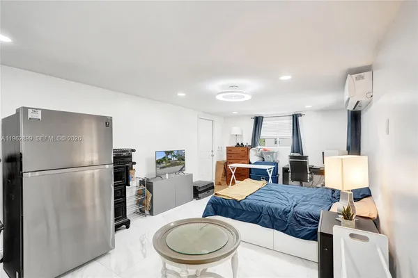 a kitchen with a refrigerator a dining table and chairs