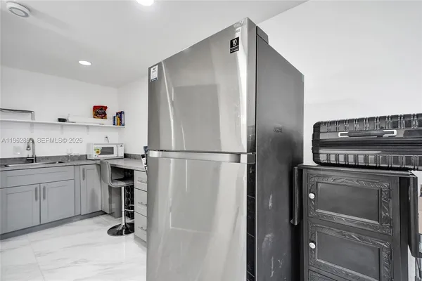 a kitchen with a refrigerator and white cabinets