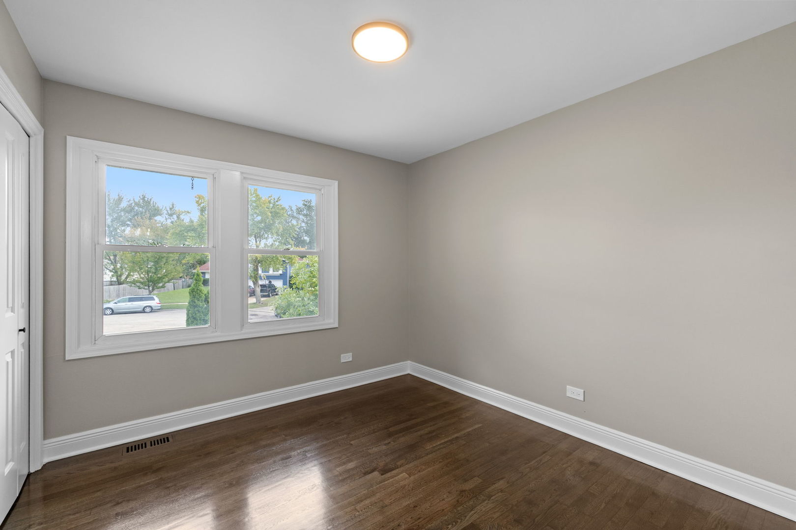 1180 Cobble Hill Court Hoffman Estates, IL 60169 - Photo 12 of 34 an empty room with wooden floor and windows