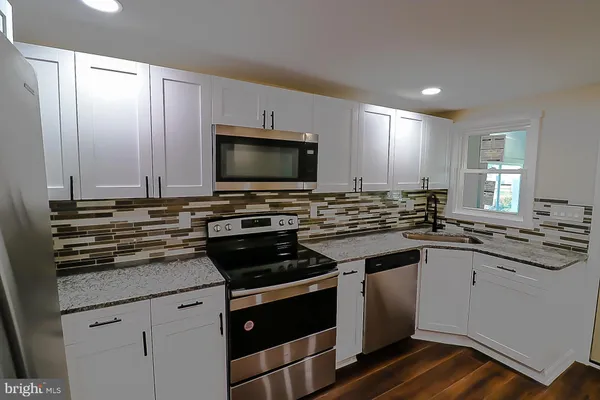 a kitchen with appliances a sink and cabinets