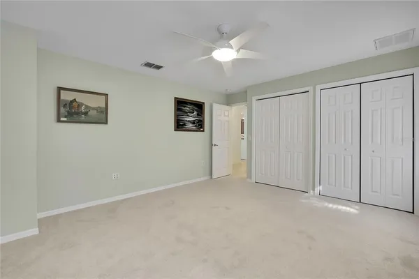 an empty room with a window and ceiling fan