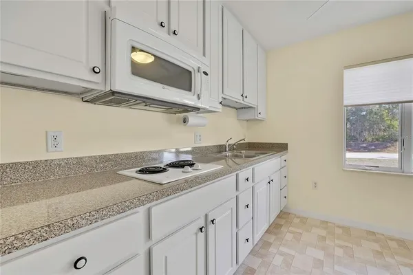 a view of a kitchen with cabinets and a refrigerator
