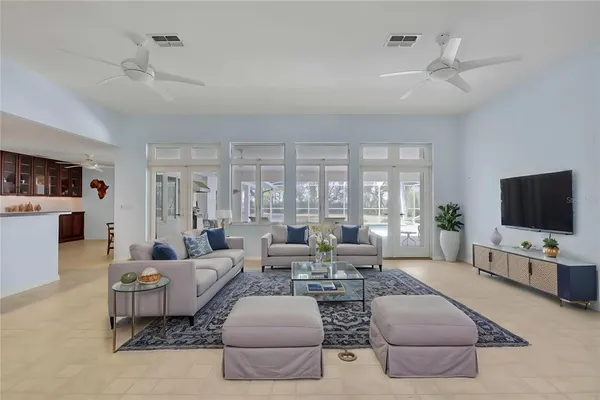 a living room with furniture flat screen tv and large window