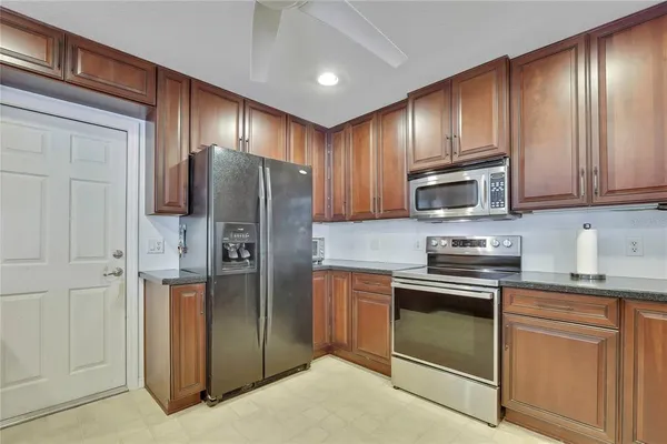 a kitchen with stainless steel appliances granite countertop a refrigerator stove and cabinets