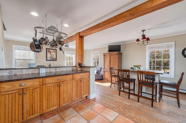 a kitchen with stainless steel appliances granite countertop a stove top oven a dining table and chairs with wooden floor