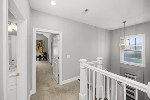 a view of a hallway with furniture and windows