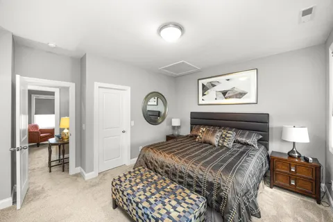 a bedroom with a bed and a lamp on dresser