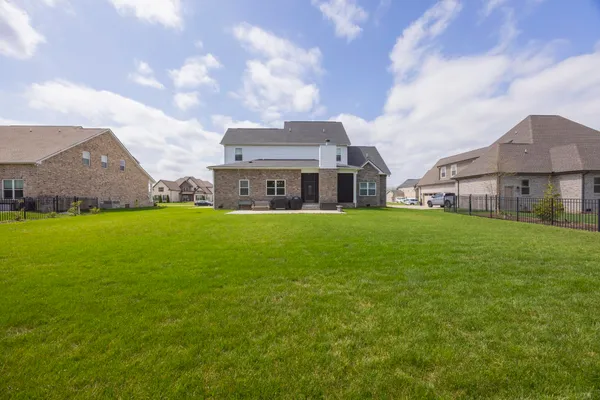 a view of a house with a big yard and large trees