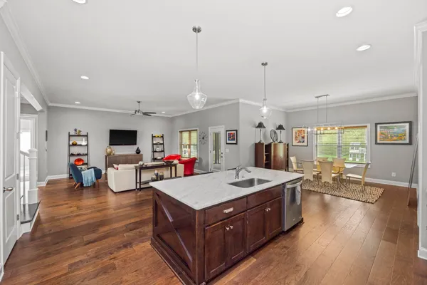 a living room with stainless steel appliances granite countertop furniture wooden floor and a view of kitchen