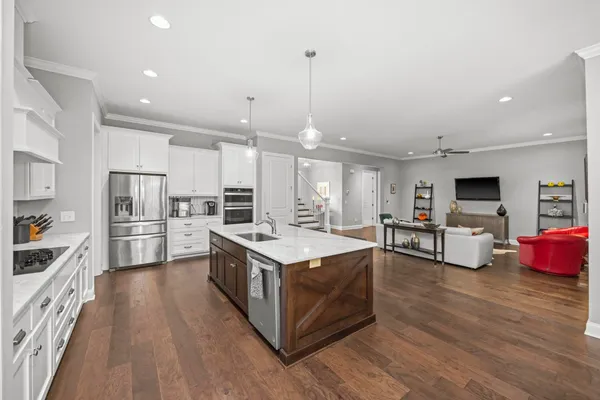 a kitchen with stainless steel appliances kitchen island granite countertop a stove and a refrigerator