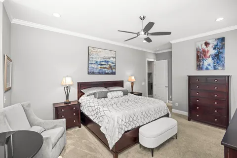 a bedroom with a bed a couch and a painting on the wall
