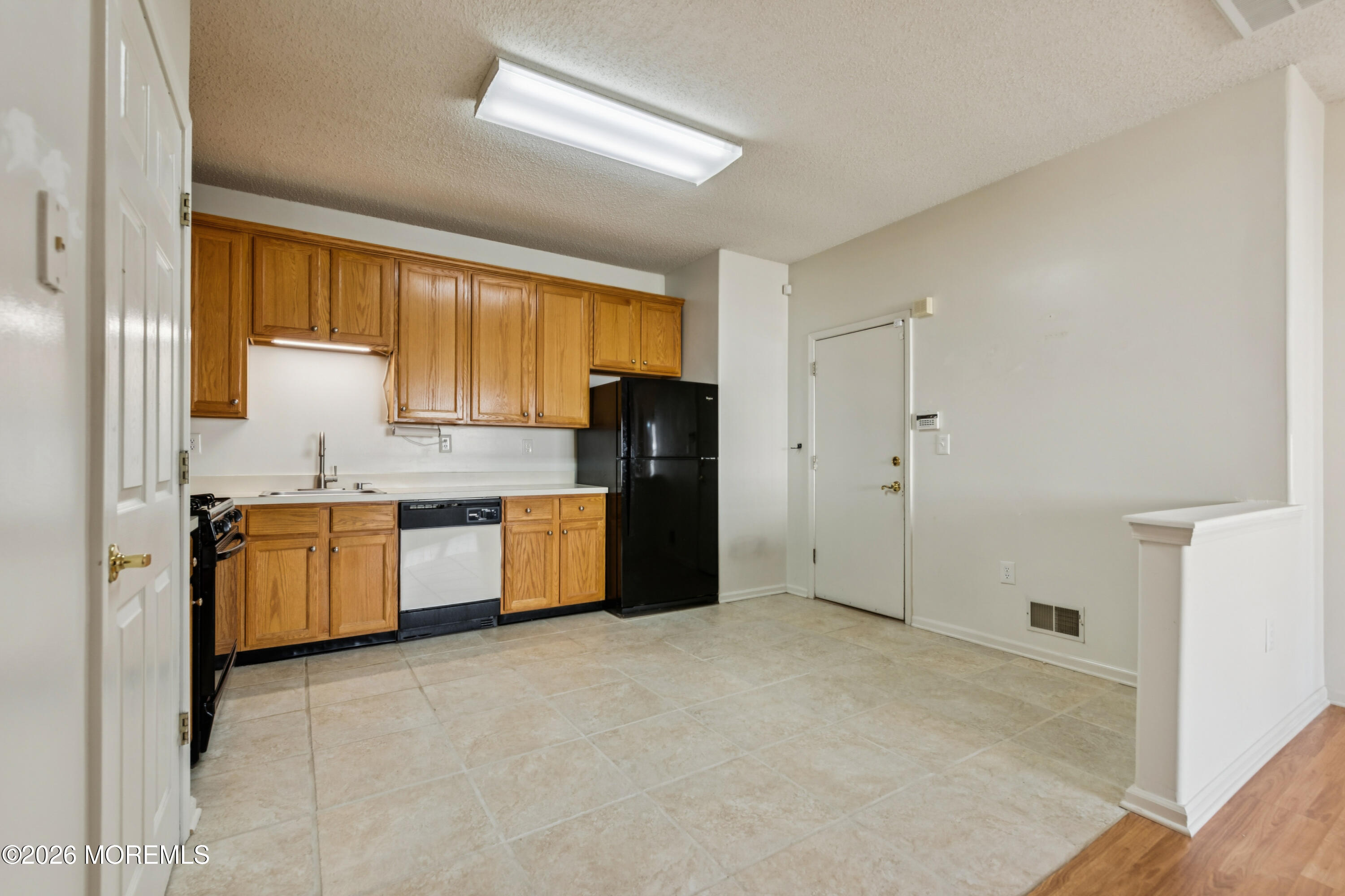 56 Riva Boulevard Brick, NJ 08723 - Photo 17 of 29 a kitchen with granite countertop a refrigerator and cabinets