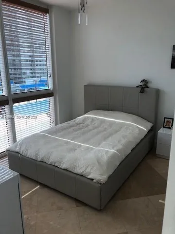 a bed sitting in a bedroom next to a window