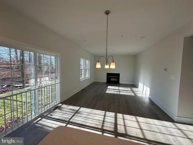a view of empty room with wooden floor and fireplace