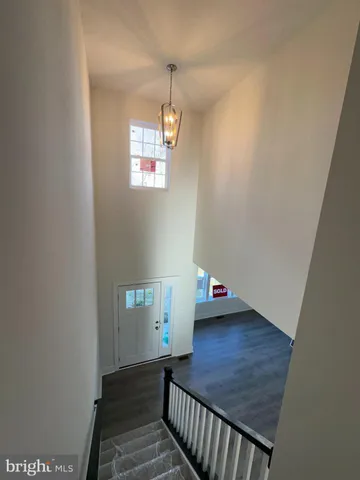 a view of a hallway with wooden floor and stairs