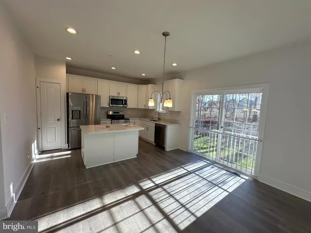 a kitchen with stainless steel appliances granite countertop a refrigerator a sink a stove and oven