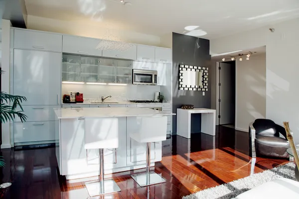 a living room with stainless steel appliances kitchen island granite countertop furniture and a wooden floor