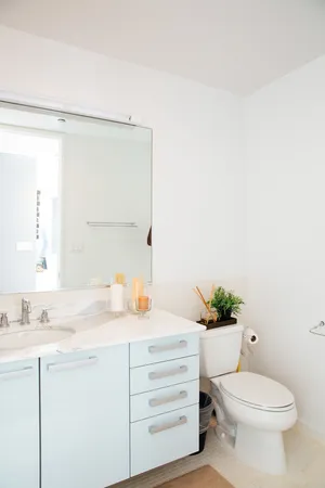 a bathroom with a granite countertop sink mirror vanity and toilet
