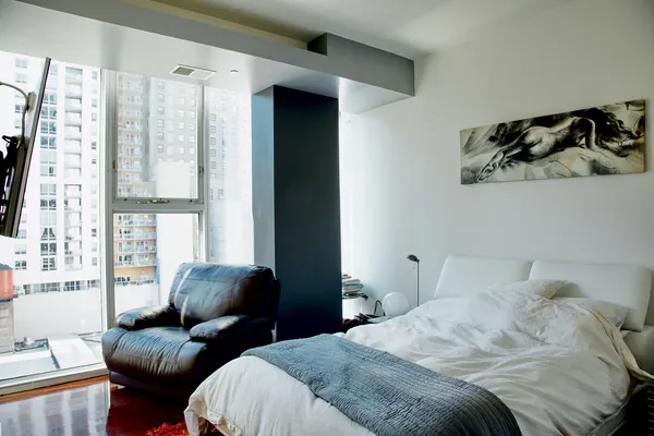 a bedroom with a bed and glass window