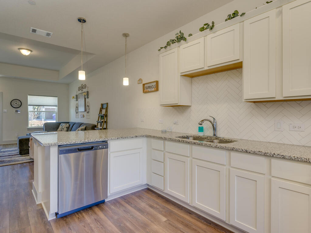 2257 Local Rebel Loop Leander, TX 78641 - Photo 11 of 26 a kitchen with granite countertop white cabinets and a sink